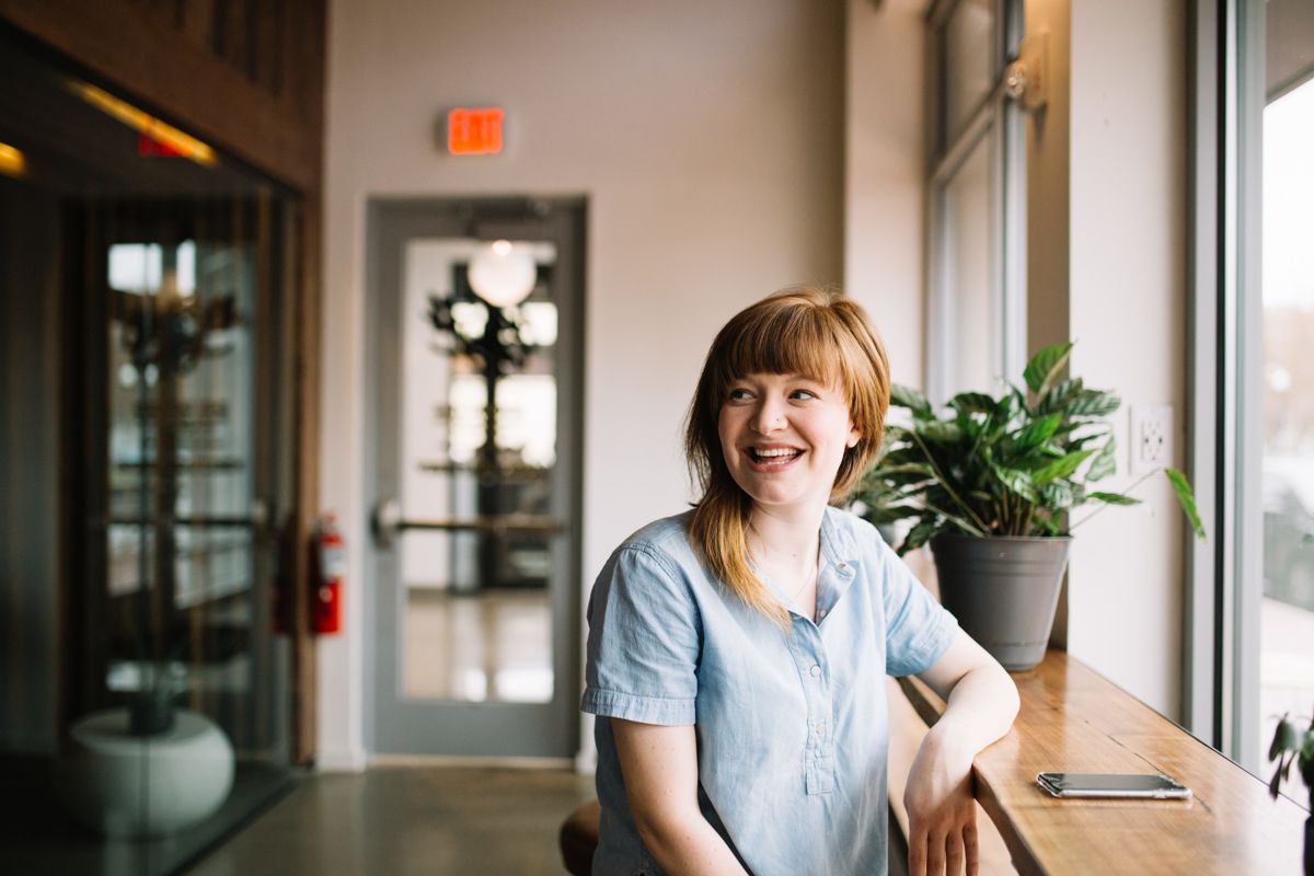 woman in blue shirt sitting at a counter top