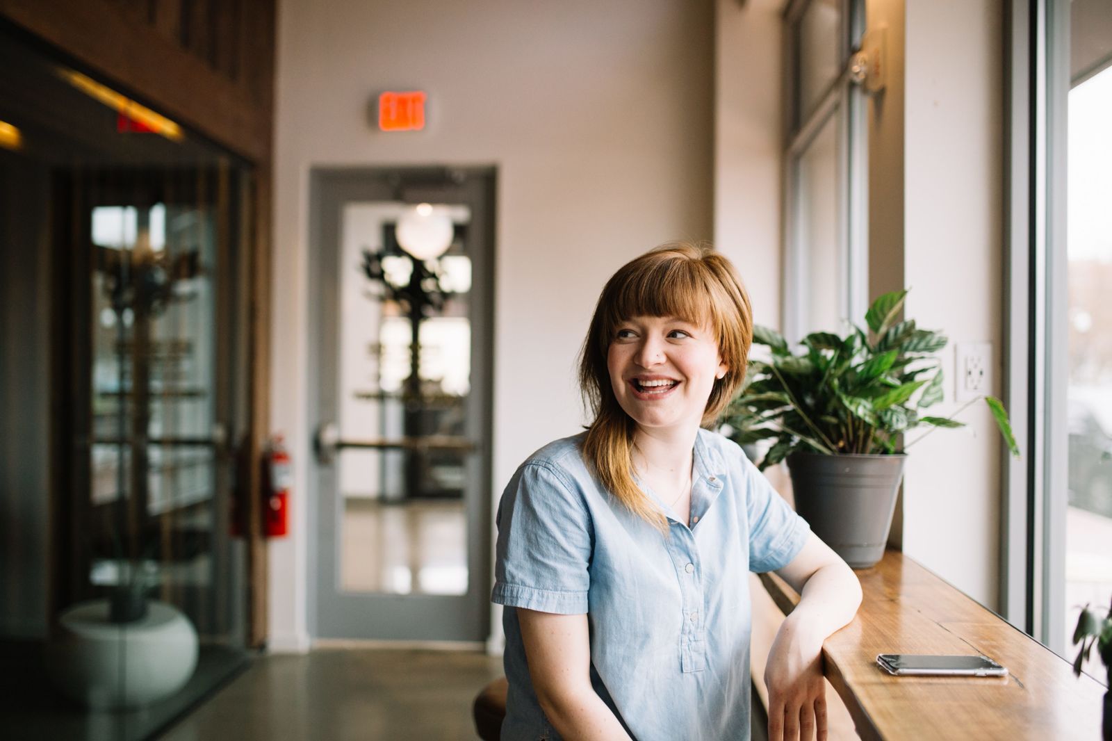 woman in blue shirt sitting at a counter top