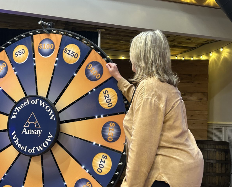 Ansay & Associates employee spinning the Wheel of Wow at Customer Experience event in 2023