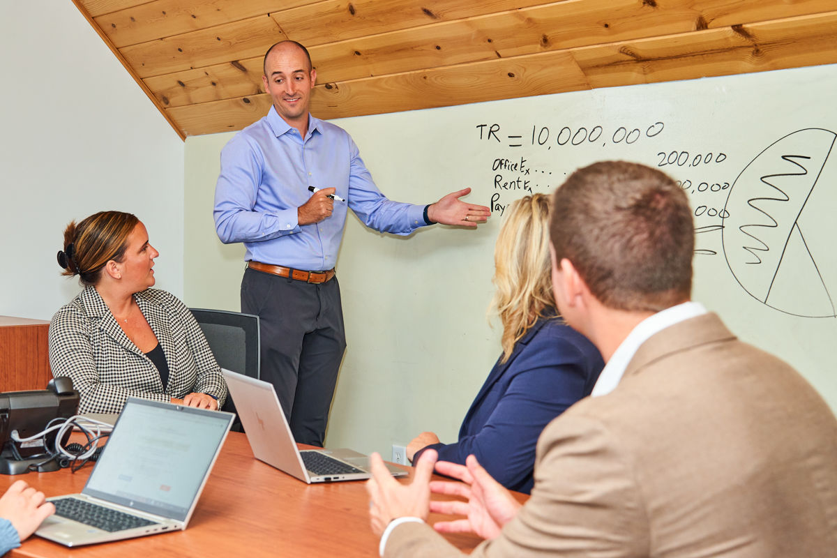 group of people in a meeting with white board