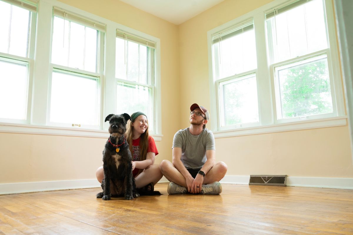 man, woman and dog sitting on the floor